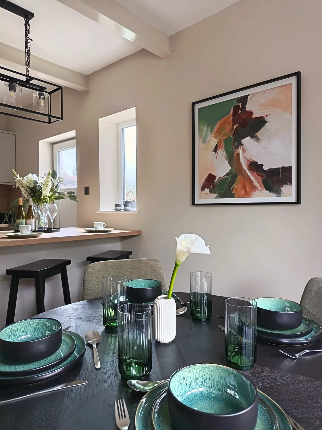 Close-up of a beautifully styled dining table with emerald green glassware